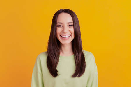 Photo of young cheerful girl happy positive smile laugh watch comedy humor isolated yellow color backgroundの写真素材