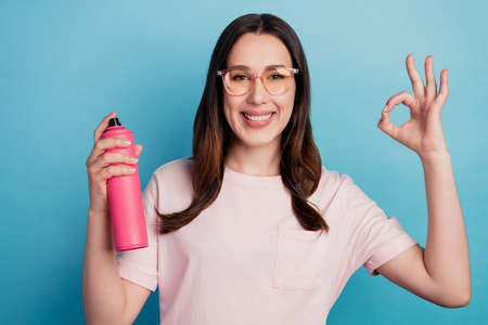 Photo of cheerful girl show okay symbol choose perfect hold bottle hair spray beauty haircare isolated turquoise color backgroundの写真素材