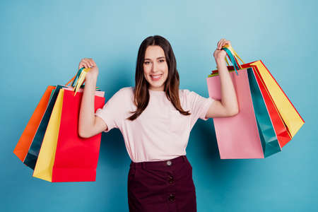 Photo of young attractive lady happy positive smile shopper store mall boutique isolated over turquoise backgroundの写真素材