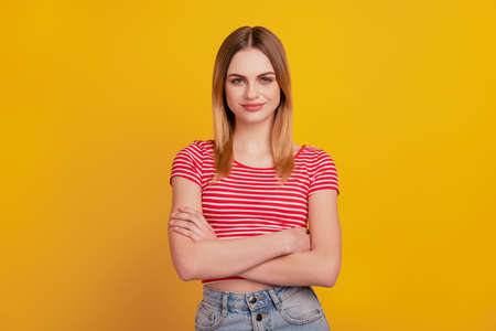 Photo of young attractive woman good mood confident crosseed hands isolated over yellow color backgroundの写真素材