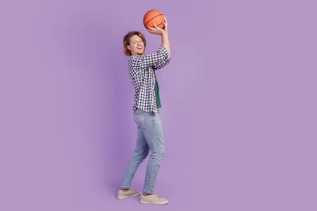 Full length photo of young man happy positive smile play basketball isolated over violet color backgroundの写真素材