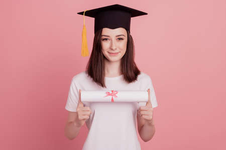 Cheerful graduate student hold diploma paper finish college study education programの写真素材