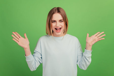 Portrait of attractive cheerful impressed girl good mood news reaction isolated over bright green color backgroundの写真素材