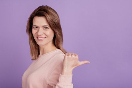 Photo of nice lady indicate thumb finger blank space sale variant wear casual shirt on violet backgroundの写真素材