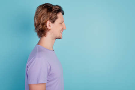 Profile side view portrait of cheerful guy good mood look empty space isolated on turquoise color backgroundの写真素材