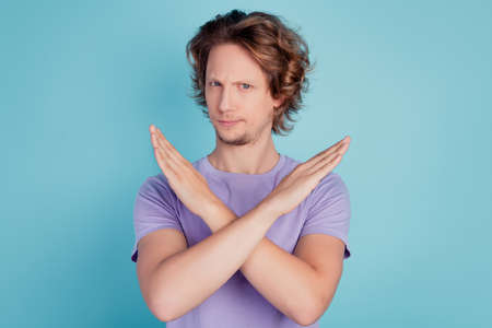Portrait of handsome brown-haired guy showing ban sign prohibition isolated over turquoise color backgroundの写真素材