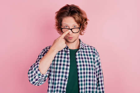 Photo of young excited business man finger fix correct eyeglasses isolated over pink color backgroundの写真素材