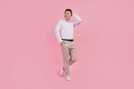 Full size photo of young asian man hand touch hair barber shop conditioner shampoo isolated over pink color backgroundの写真素材