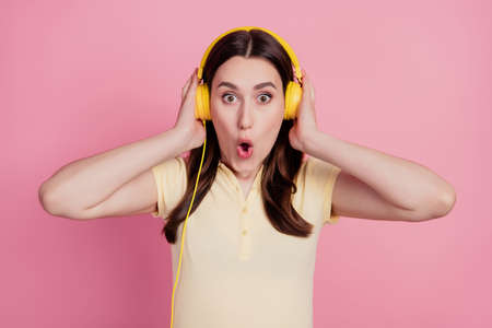 Photo of crazy speechless stunned amazed lady wear headphones listen news on pink backgroundの写真素材