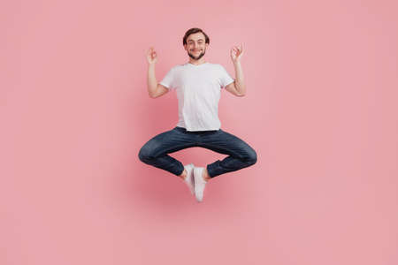 Full size photo of young happy excited smiling positive man meditate yoga om isolated on pink color backgroundの写真素材