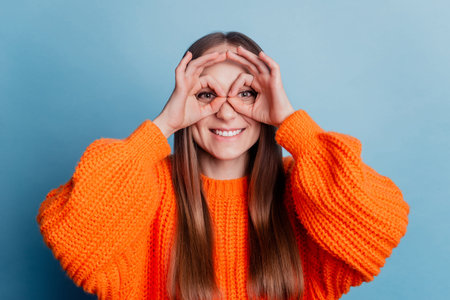 Photo of young cheerful girl fooling playful show okey sign watch see fingers glasses isolated over...