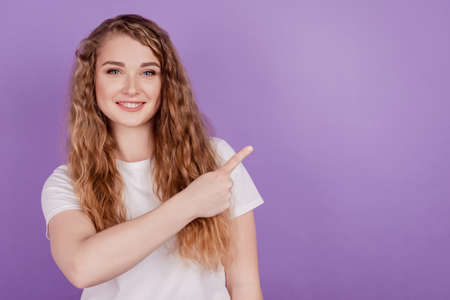 Photo of advertiser adviser redhead promoter lady direct finger empty space wear casual outfit on violet backgroundの写真素材