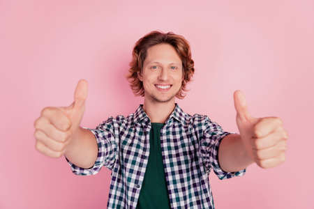 Photo of young excited man show thumbs-up like cool advertise choice advertise isolated over pink color backgroundの写真素材