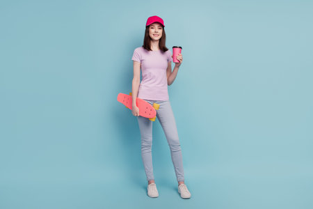 Full length photo of young girl sporty drink americano skateboard walk hat isolated turquoise color...