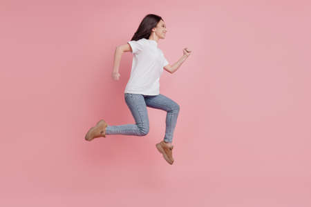 Full size profile side photo of young girl go walk run hurry sale isolated over pink color backgroundの写真素材