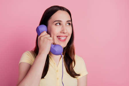 Photo of dreamy thoughtful lady hold telephone make call look empty space on pink backgroundの写真素材