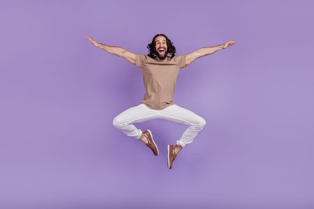 Full size photo of young cheerful latin man good mood jump up carefree isolated on purple color...