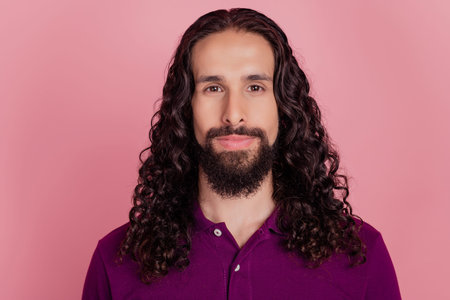 Long haired bearded worker employee man look camera wear purple t-shirt isolated on pink background