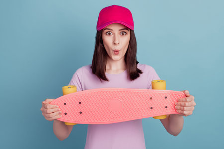 Photo of young girl excited skateboard rider headwear cool pouted lips isolated turquoise color...