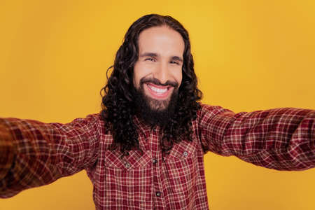 Cheerful nice candid influencer long hairdo make selfie beaming smile isolated on yellow backgroundの写真素材