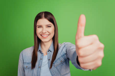 Photo of young cheerful woman show thumb-up excellent great perfect ideal isolated over green color backgroundの写真素材