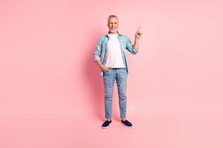 Full length photo of senior man indicate finger empty space advertise promotion isolated over pink...
