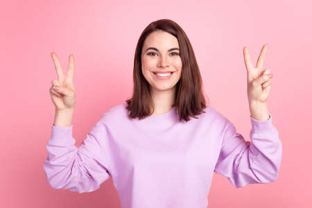 Photo of youth excited adorable girl show peace victory v-symbol isolated over pink color backgroundの写真素材