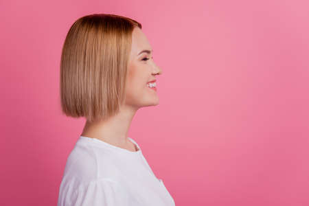 Profile photo of cheerful lady beaming toothy smile look empty space wear white t-shirt isolated on pink backgroundの写真素材