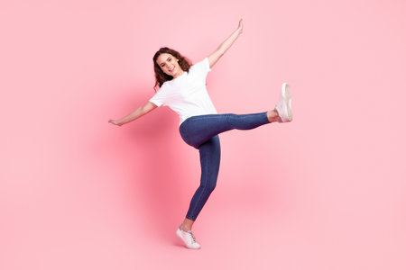 Full body photo of young charming lady have fun playful wear casual outfit isolated over pink color backgroundの写真素材