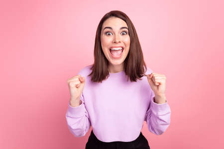Photo of young lady excited rejoice victory yell success fists hands goal fan isolated over pink color backgroundの写真素材