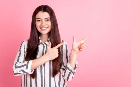 Photo of cheerful girl point finger empty space ad promo choose suggest isolated over pink color backgroundの写真素材