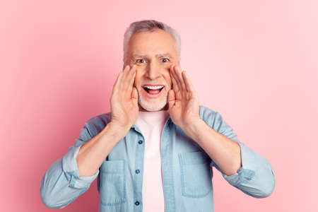 Photo of cheerful senior man arms near mouth advertise scream information discount promoter isolated over pink color backgroundの写真素材