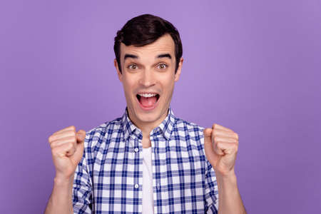 Photo of young excited man rejoice victory fists hands discount lucky isolated over violet color backgroundの写真素材