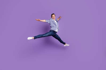 Full body profile side photo of young handsome man have fun jump up isolated over violet color backgroundの写真素材