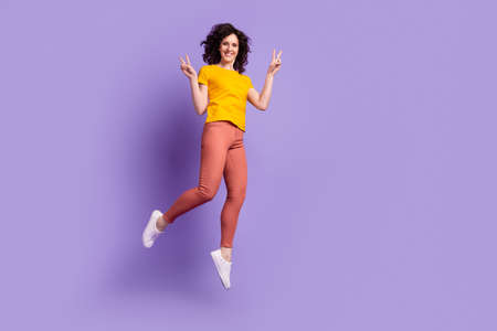 Full length photo of young charming woman good mood jumper show peace cool v-symbol isolated over violet color backgroundの写真素材