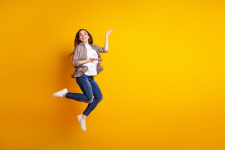 Full body profile side photo of young girl demonstrate product offer advertise isolated over yellow...