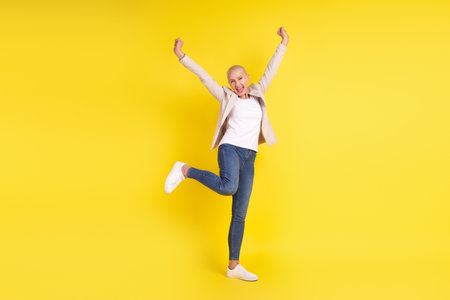 Full size photo of cheerful senior lady have fun rejoice victory discount win lottery isolated over yellow color backgroundの写真素材