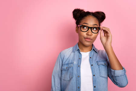 Photo of young african woman dreamy look empty space thoughtful plan isolated over pink color backgroundの写真素材