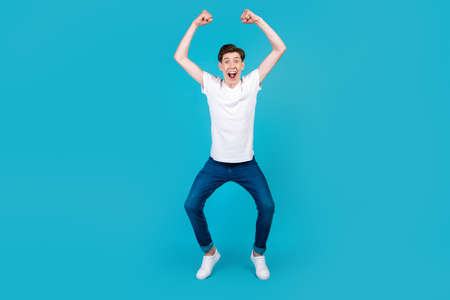 Full body photo of young excited man good mood rejoice victory triumph success isolated over blue color backgroundの写真素材