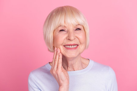 Photo of senior lovely lady arm touch chin good mood skin care dreamy isolated over pink color...
