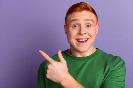 Photo of young cheerful man indicate finger empty space proposition select discount isolated over violet color backgroundの写真素材