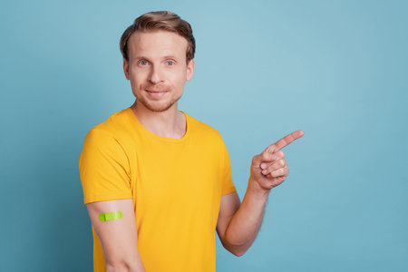 Confident guy presenting empty space plaster vaccination concept wear casual clothes isolated on...