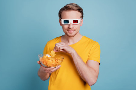 Funny guy enjoy cinema 3d experience eat chips wear casual clothes isolated on turquoise backgroundの写真素材