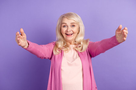 Photo of mature cheerful lady open arms welcome meeting grandchild isolated over purple color...