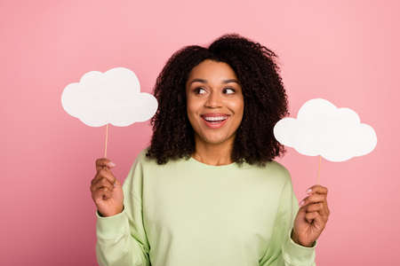 Photo of youth cheerful woman guess look empty space hold paper poster isolated over pink color backgroundの写真素材
