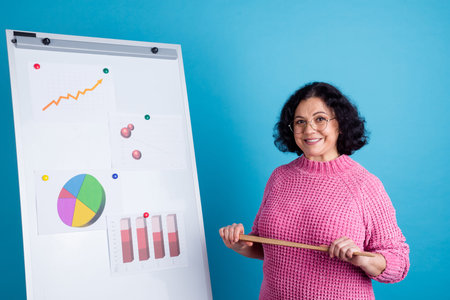 Happy senior female leader showing drawing chart happy showing presentation,looking at camera and...