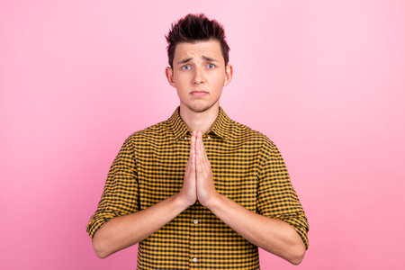 Young boyfriend pleads for something asks for favour keeps palms pressed together