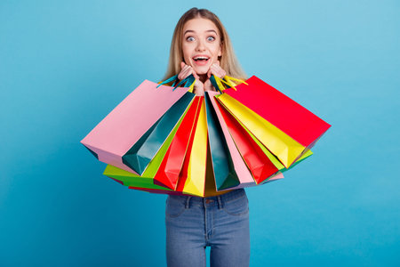 Portrait of attractive dreamy cheerful straight-haired girl holding carrying new things isolated on...