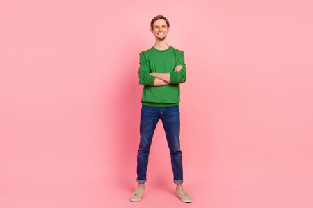 Portrait of stunning smiling cool man having his arms crossed looking at camera isolated on pastel color backgroundの写真素材