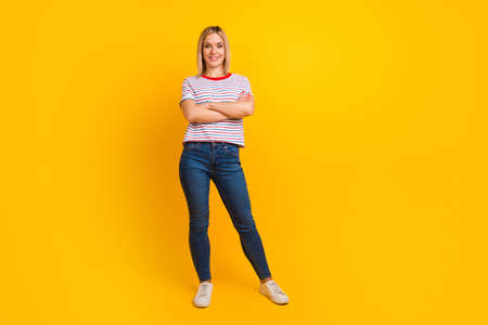 Photo portrait full length of woman standing with arms crossed isolated on vivid colored backgroundの写真素材